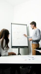 A businessperson giving a presentation with charts in a modern office environment.